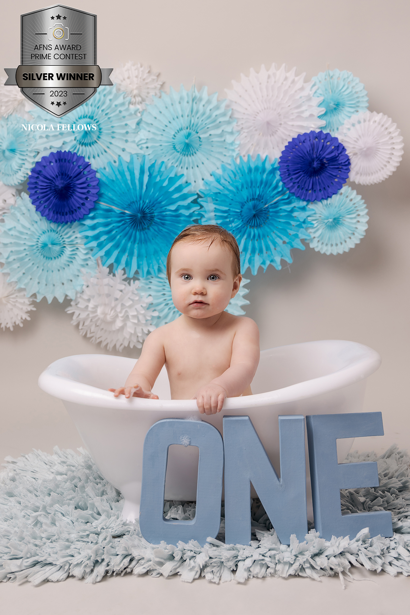 Baby boy turning one celebrating with a cake smash in Sutton Coldfield birmingham, blue themed bubble bath.