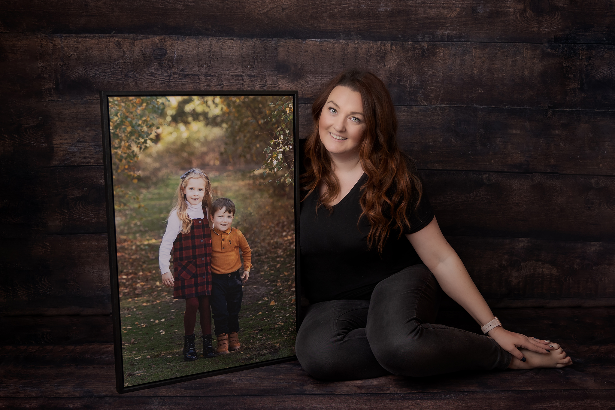 family photographer from Sutton Coldfield Birmingham holding a beautiful piece of wall art of two gorgeous children
